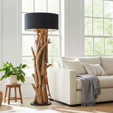 Load image into Gallery viewer, Living room with a beige sofa, wooden floor lamp, and decorative items.