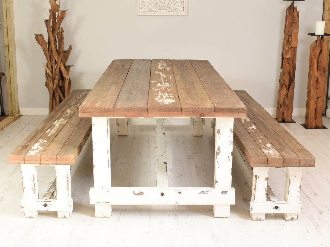 Reclaimed pine farmhouse dining table with distressed white finish paired with 2 benches